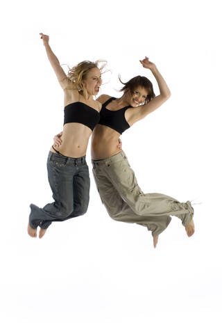 Zwei junge Frauen springen in der Luft, lizenzfreies Stockfoto