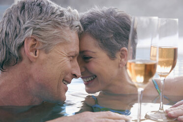Älteres Paar mit Champagner im Schwimmbad, Porträt - WESTF07738