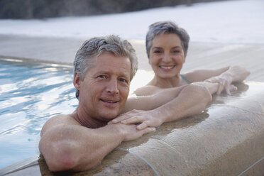 Mature couple relaxing in outdoor spa, portrait - WESTF07734