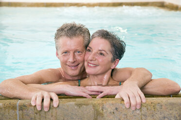 Mature couple embracing in swimmingpool, portrait - WESTF07672