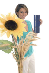 Frau hält Solarzellen, Sonnenblume im Vordergrund - WESTF07429