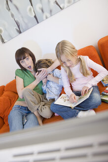 Mother and children watching television together - WESTF07358