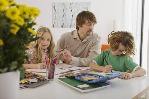 Vater und Kinder bei den Hausaufgaben, lizenzfreies Stockfoto