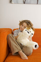 Junge (6-7), der einen Teddybär umarmt, Porträt - WESTF07290