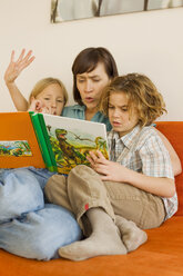 Mother reading story book to children - WESTF07274