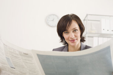Businesswoman reading newspaper, portrait - WESTF07857