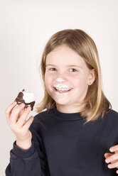 Blondes Mädchen (8-9), das einen Marshmallow aus Schokolade hält, Porträt - UMF00178