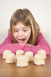 Mädchen (6-7) schaut sich Schokoladen-Marshmallows an, albert herum - UMF00172