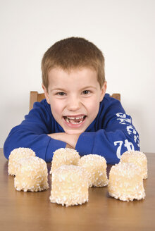 Junge (8-9) mit Blick auf Schokoladen-Marshmallows, Porträt - UMF00171
