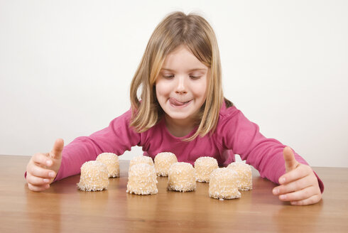 Mädchen (6-7) schaut sich Schokoladen-Marshmallows an, albert herum - UMF00170