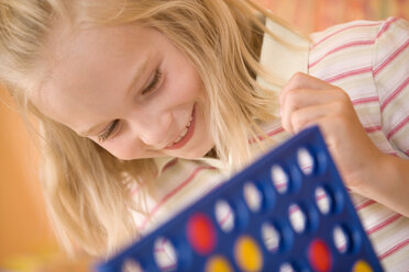 Girl (8-9) playing a game, smiling - HKF00216