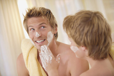 Vater und Sohn (10-11) mit Rasierschaum im Gesicht im Badezimmer - HKF00200