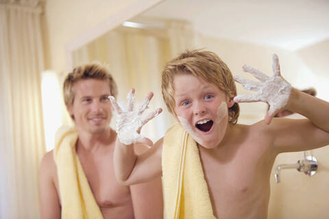 Vater und Sohn (10-11) im Badezimmer, lizenzfreies Stockfoto