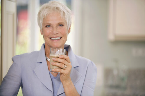 Woman holding drink glass, smiling, portrait - HKF00184