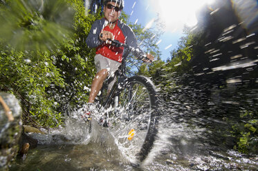 Mountainbiker beim Überqueren eines Baches - HHF01928