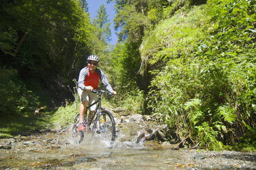 Mountainbiker beim Überqueren eines Baches - HHF01920