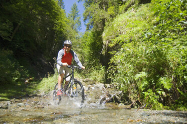 Mountainbiker crossing brook - HHF01920