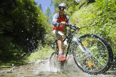 Mountainbiker crossing water - HHF01917