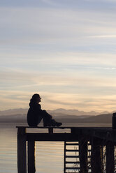 Germany, Bavaria, Ammersee, woman sitting on landing stage - UMF00201