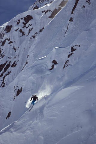 Österreich, Arlberg, Albona, Mann beim Skifahren in den Alpen, lizenzfreies Stockfoto