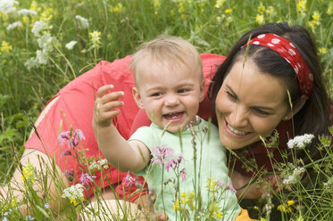 Mutter mit Babygrille (2-3) auf der Wiese, Porträt - HHF01937