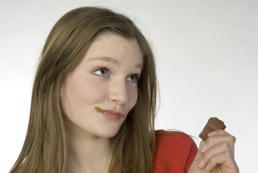 Brünettes Mädchen (13-14) isst Schokolade, Porträt - NHF00729