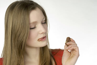 Brunette girl (13-14) eating chocolate - NHF00728