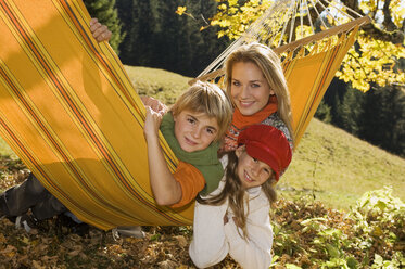 Austria, Salzburger Land, Altenmarkt, Mother and children lying in hammock, smiling, portrait - HHF02270