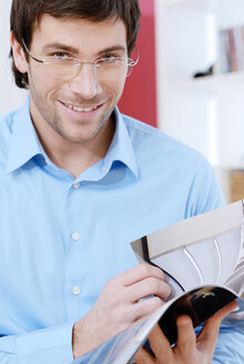 Young man holding a magazine - VRF00072
