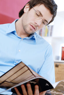 Young man reading a magazine - VRF00071