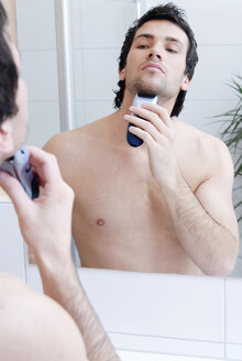 Young man man using electric razor, portrait - VRF00067
