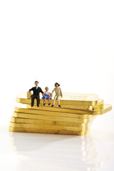 Plastic figurines sitting on gold bars - 08596CS-U