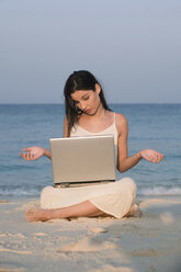 Asien, Thailand, Junge Frau mit Laptop am Strand, Porträt - RDF00690