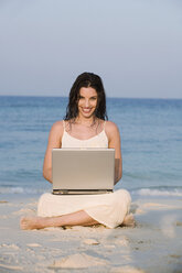 Asien, Thailand, Junge Frau mit Laptop am Strand, Porträt - RDF00689