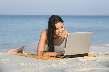 Asien, Thailand, Junge Frau mit Laptop am Strand, Porträt - RDF00688