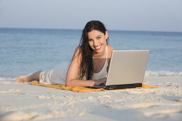 Asien, Thailand, Junge Frau mit Laptop am Strand, Porträt - RDF00686