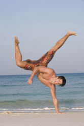 Asien, Thailand, Junger Mann übt Capoeira am Strand - RDF00683
