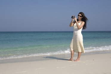Asien, Thailand, Junge Frau filmt am Strand - RDF00663