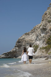 Asien, Thailand, Junges Paar geht Hand in Hand am Strand entlang, Rückansicht - RDF00653