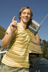Deutschland, Bayern, Junger Mann trägt ein Transistorradio auf der Schulter - RDF00573