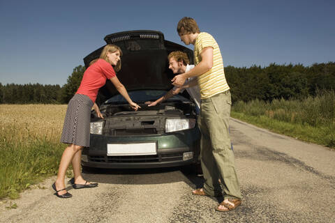 Deutschland, Bayern, Drei Freunde mit Autopanne, lizenzfreies Stockfoto