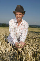 Germany, Bavaria, Farmer examining wheat growing in field - RDF00512