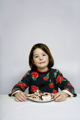 Porträt eines Mädchens (8-9), das ein Stück Kuchen isst - PMF00573