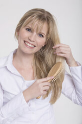 Young woman combing her hair, portrait - RDF00882