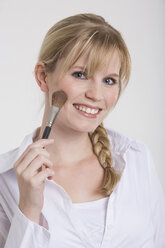 Young woman using a make-up brush - RDF00880