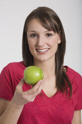 Young woman holding an apple, portrait - RDF00846
