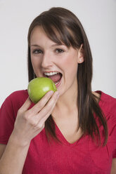 Young woman holding an apple, portrait - RDF00845