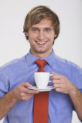 Junger Mann mit Tasse Kaffee, Porträt - RDF00824
