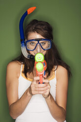Young woman wearing diving goggles, holding a water pistol - RDF00760