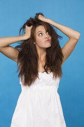Junge Frau, die sich die Haare rauft, Porträt - RDF00751
